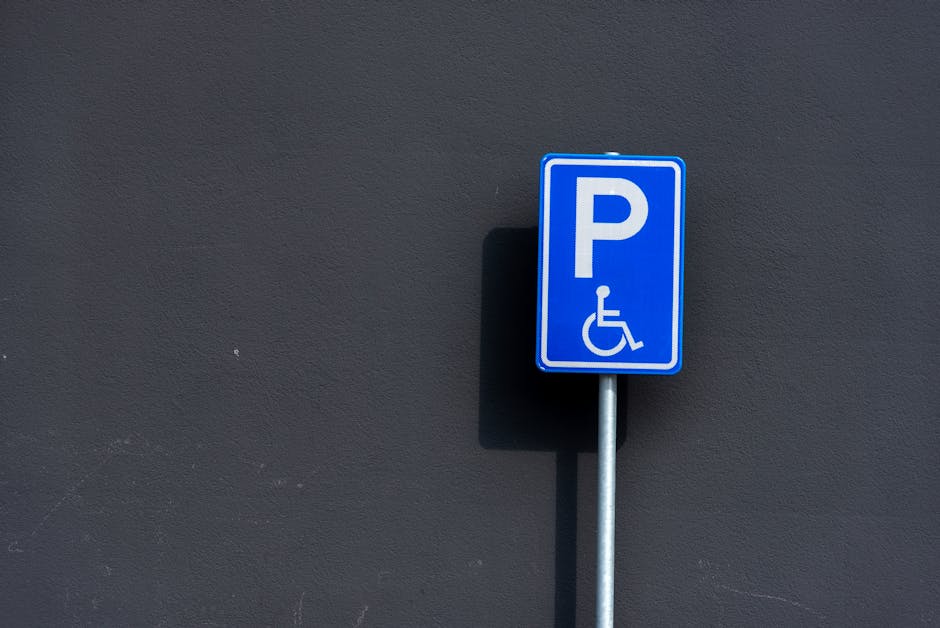 A green and white parking restriction sign mounted on a metal pole, indicating a two-hour parking limit from 8 am to 8 pm daily, except Sundays, in Wallington. The sign is positioned outdoors against 